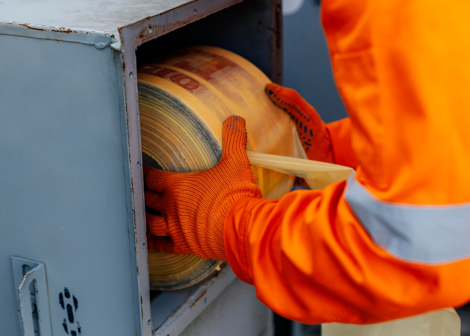 Worker handling large roll of material