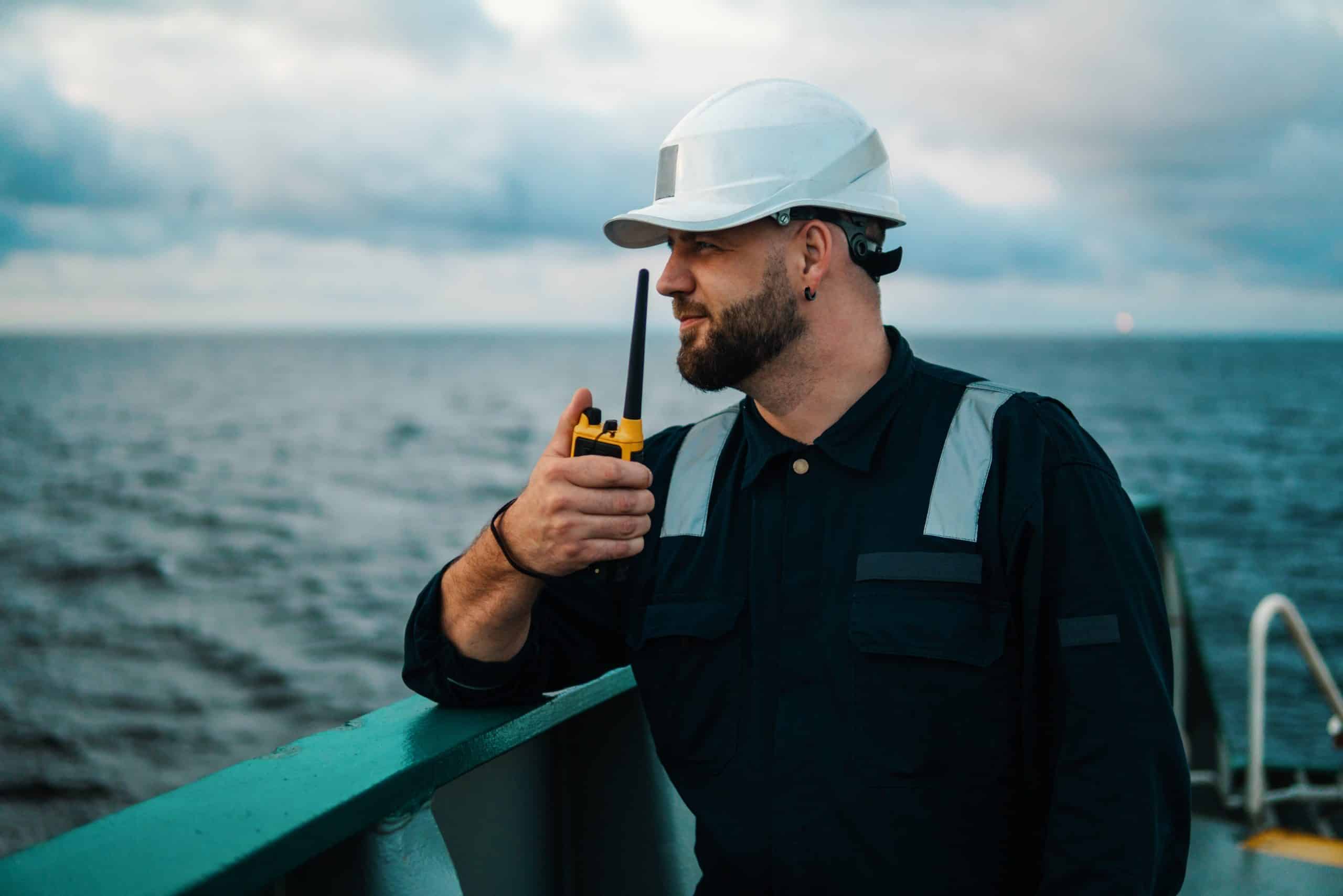 Officer communicating on a ship deck.