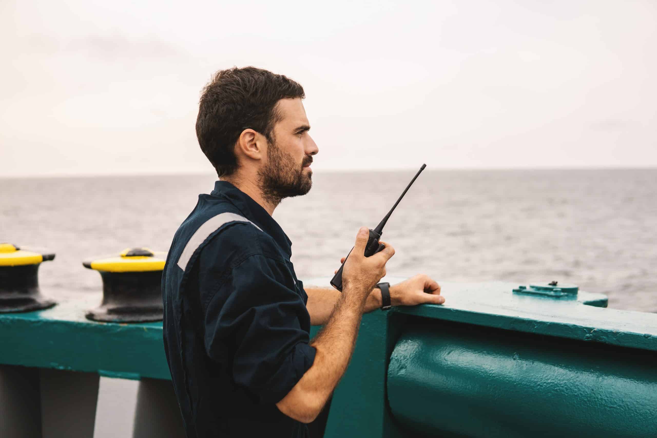 Officer communicating on ship's deck.
